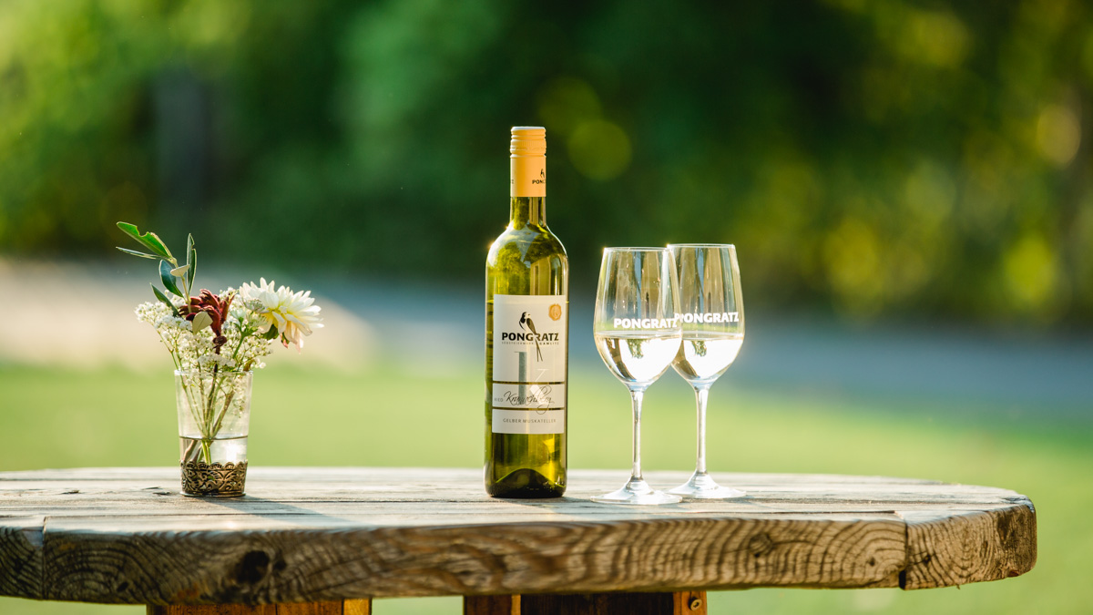 Weinflasche und Gläser am Holztisch, Weingut Pongratz - Foto © Karin Bergmann